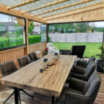 Impressionsbild Terrassenüberdachung aus Holz mit niedrigen und hohen Glasschiebewänden in anthrazit/graphitgrau RAL 7024