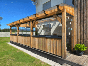 Glasschiebewand mit Glastür für Holz-Sommergarten bei blauem Himmel