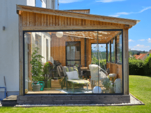 Glasschiebewand in verwetterter Holzkonsturktion in grüner Wiese